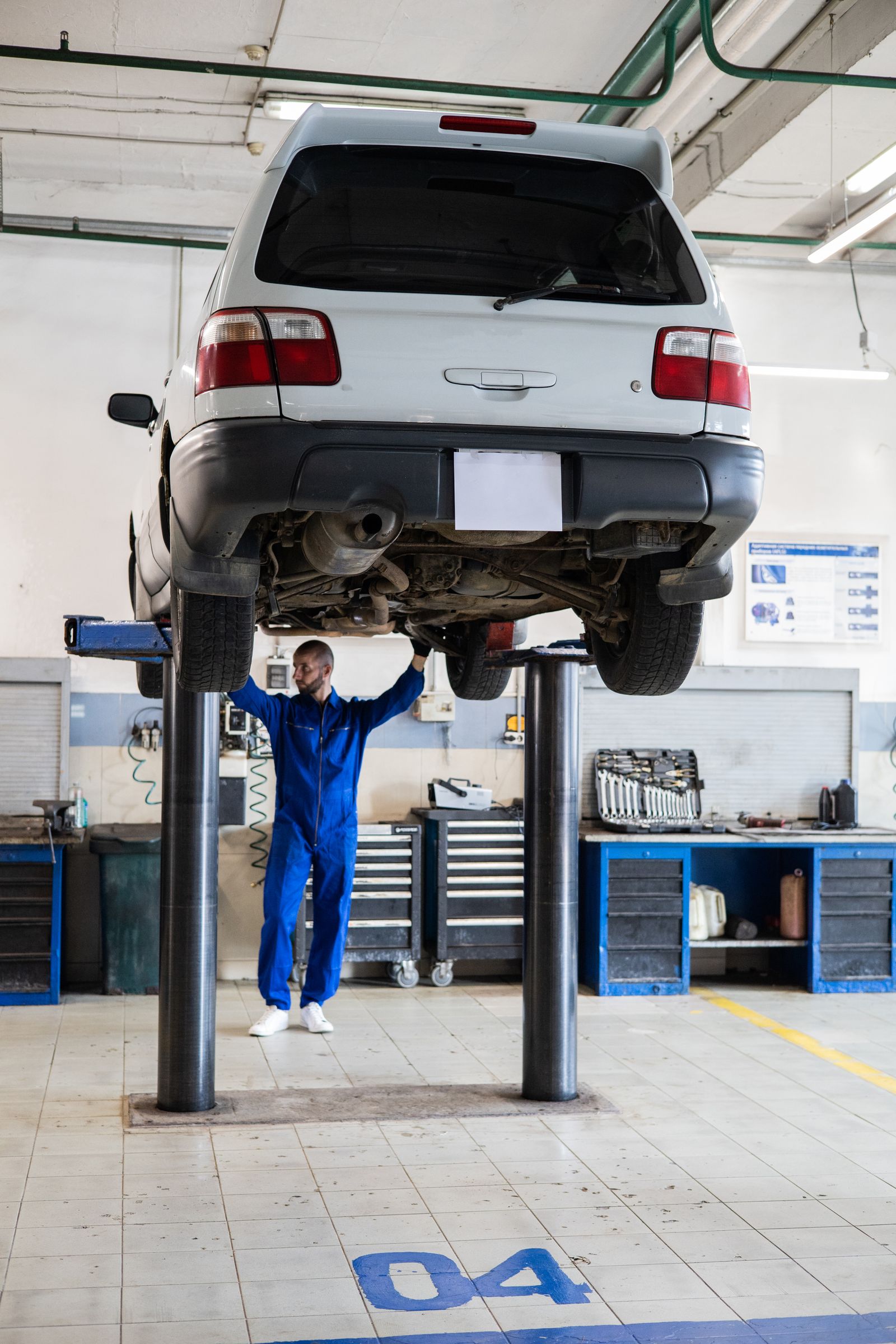 Technician working beneath a car on the lift